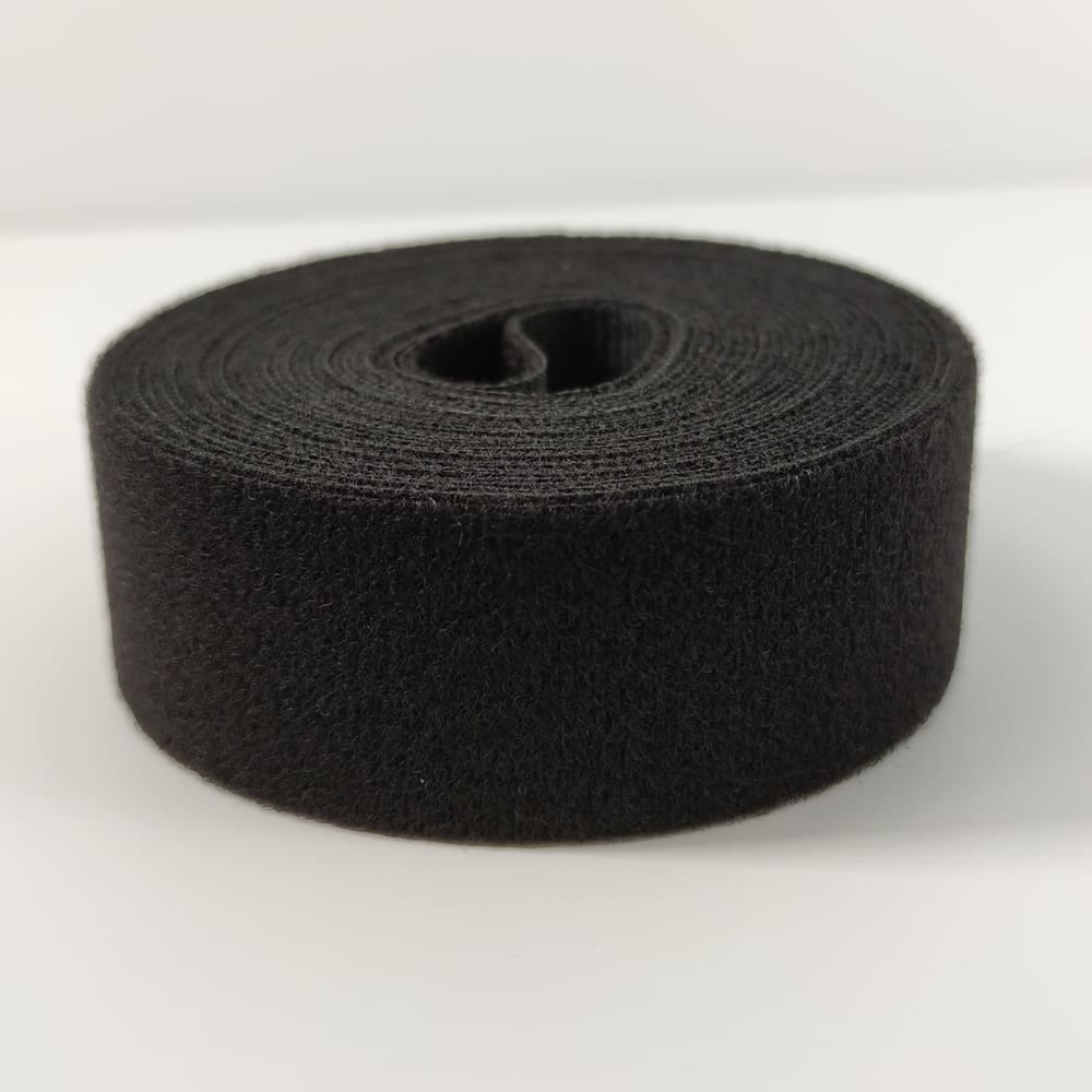 Schwarzes Textil Flauschband, aufgerollt.
